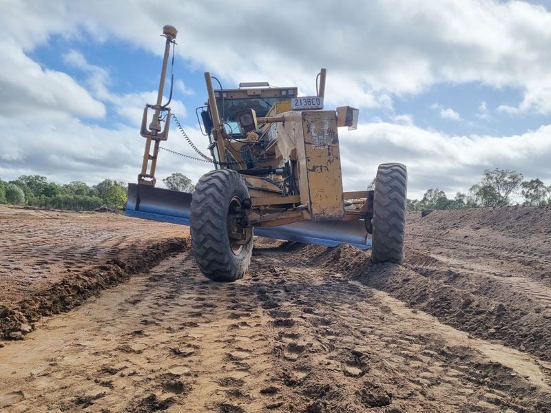 CAT 12H grader shaping a rural road